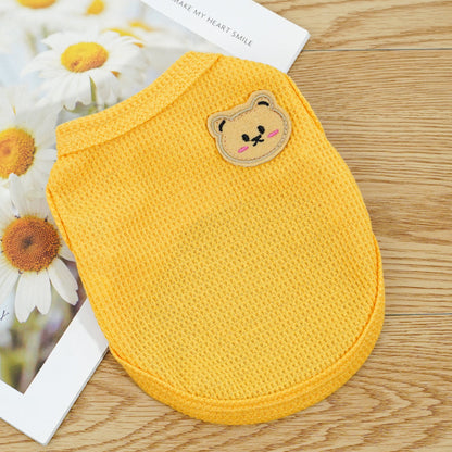 Yellow pet vest with a cute bear patch detail, soft and comfortable pet apparel flat lay
