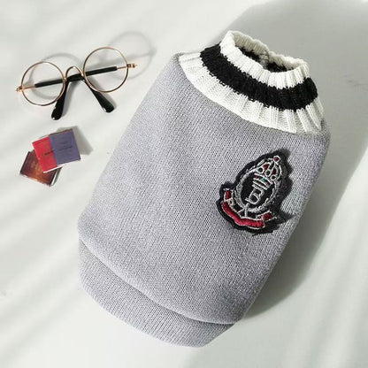 Grey knitted pet sweater vest with a formal crest emblem patch for autumn and winter wear
